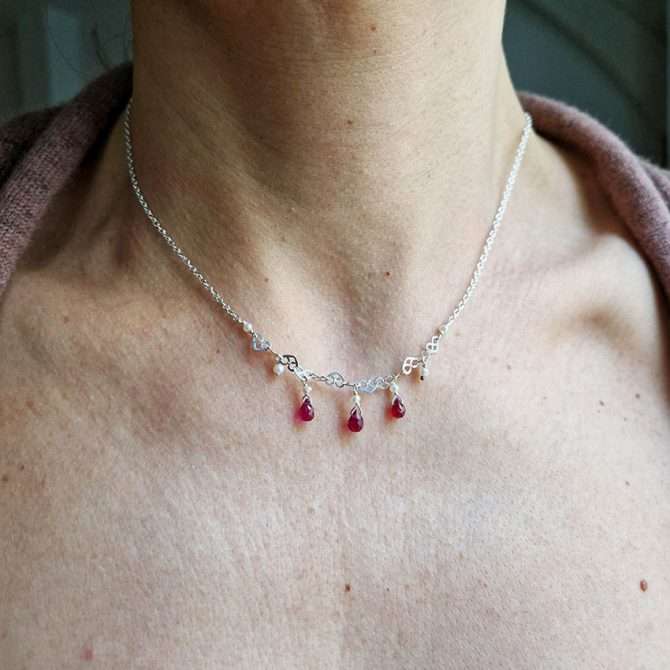 Collier ras du cou en argent massif avec trois gouttes de rubis rouges et perles blanches, porté au cou pour femme